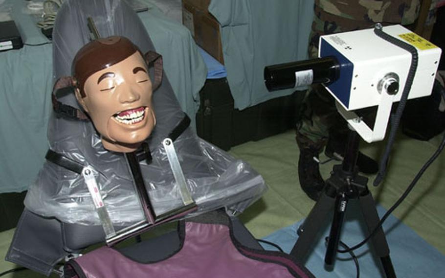 Most equipment in the Expeditionary Medical Support package is lightweight and portable. Here, a tube takes dental x-rays, which are transmitted to a laptop computer for review.