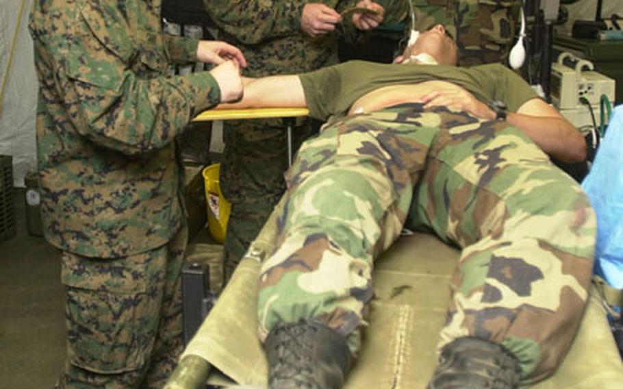 Navy surgeons prepare a simulated victim for "surgery" in the Forward Resuscitative Surgical System operating room Oct. 23 during exercise Autumn Endeavor at Camp Hansen. The FRSS is a mobile medical facility designed to be next to the front lines to treat the most critical troops.