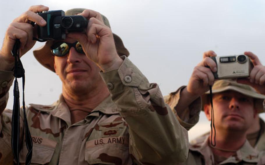 Soldiers armed with digital cameras photograph the ribbon-cutting Saturday at the 14th of July Bridge in central Baghdad.