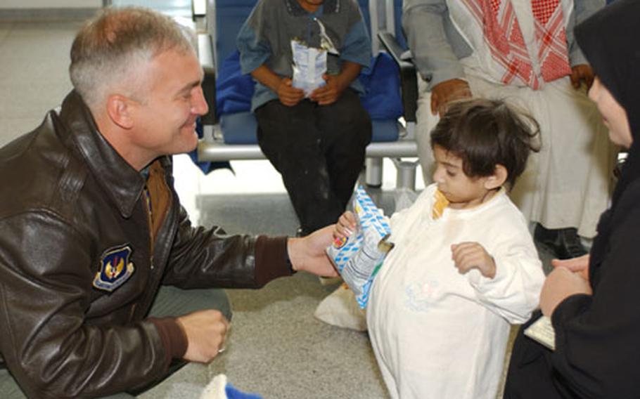 Brig. Gen. Erwin F. Lessel III, 86th Airlift Wing commander, Ramstein Air Base, Germany, hands a snack to one of the 18 Iraqi children who arrived at Ramstein Air Base on Oct. 6. The children were flown in by the U.S. Air Force from Baghdad International Airport, to receive medical care from hospitals throughout Rhineland-Pfalz, Germany.