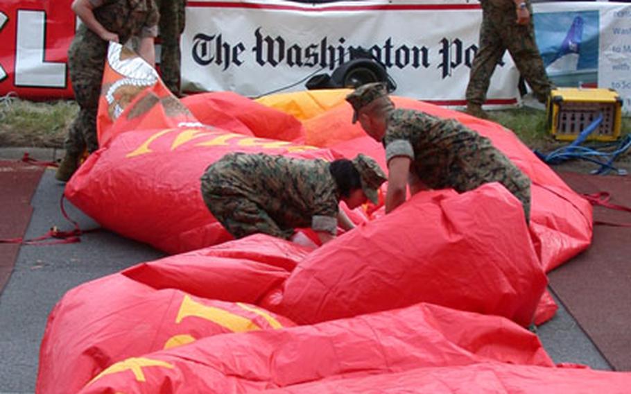 U.S. Marine volunteers from Marine Corps Base Quantico begin to fold up the "start" arc after the last of the runners left the start line for the 28th Marine Corps Marathon, held Sunday in and around the nation&#39;s capital.