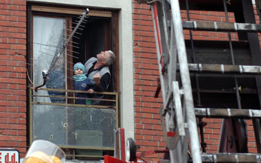 A family looks out the window as firefighters demonstrate their capabilities.