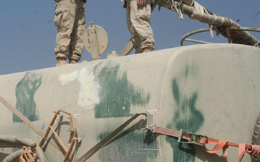 Soldiers fill up a water truck at LSA Anaconda, Iraq. The base is home to about 15,000 soldiers.