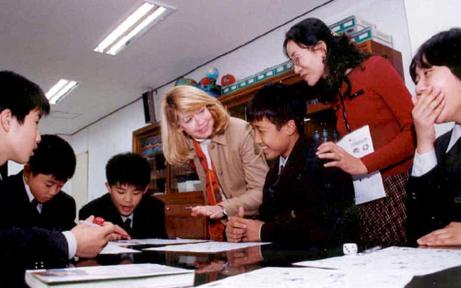 Margaret Wood, wife of the 2nd Infantry Division commander, and Shim Sook-hyun, a Jisan Middle School English teacher, show the students how to play an English language game.