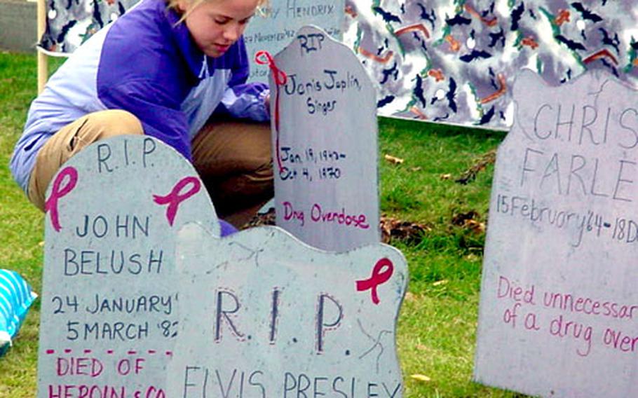 Ashely McNamara, 12, adjusts tombstone Friday in a mock graveyard of celebrities who died from drug-related causes. The celebrity graveyard is one of several student activities in observance of national Red Ribbon Week, which takes place in the last week of October.
