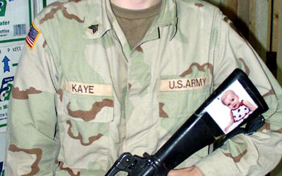 Sgt. Benjamin Kaye has a picture of his daughter taped to the stock of his rifle. Kaye is dismayed that he was not allowed to return home for even a week after his daughter had surgery for spina bifida that rendered her paralyzed from the waist down. Military officials say being allowed to return to the States for emergency leave varies widely from unit to unit based on operational tempo and an individual&#39;s military job.