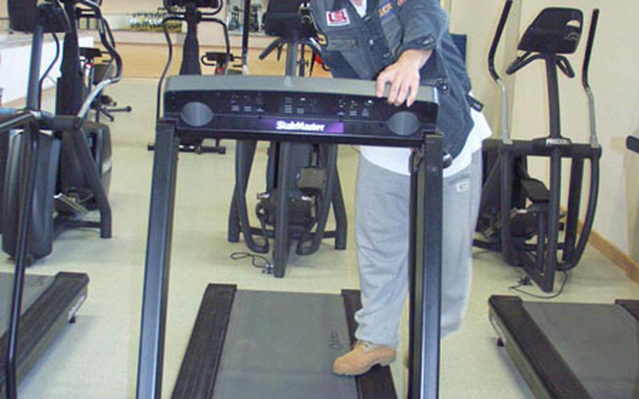 Sgt. Omar Castro of the 4th Battalion, 3rd Air Defense Artillery, makes adjustments to a treadmill at the Army&#39;s Larson Barracks in Kitzingen, Germany. The Larson gym reopened Wednesday after a yearlong, $2 million makeover.