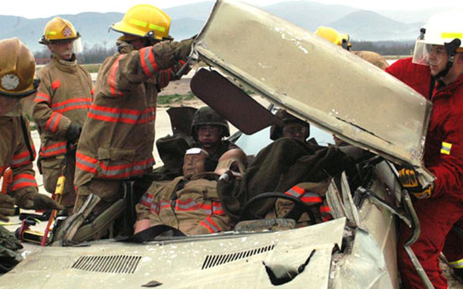 Firefighters remove the car roof to extract those injured during an exercise with Task Force Med Eagle on Saturday at Eagle Base, Bosnia and Herzegovina. A couple of medics crawled into the back of the car to stabilize the necks of the casualties - practice dolls.