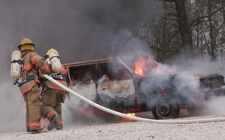 Brown and Root firefighters extinguish a burning car during an exercise with Task Force Med Eagle on Saturday at Eagle Base, Bosnia and Herzegovina.