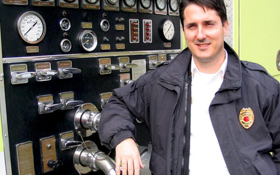 Assistant Fire Chief Jerry Clark stands near a control panel on the fire engine that officially becomes the property of the new Station 15 at Sasebo Naval Base&#39;s Harioshima Ordnance Facility.