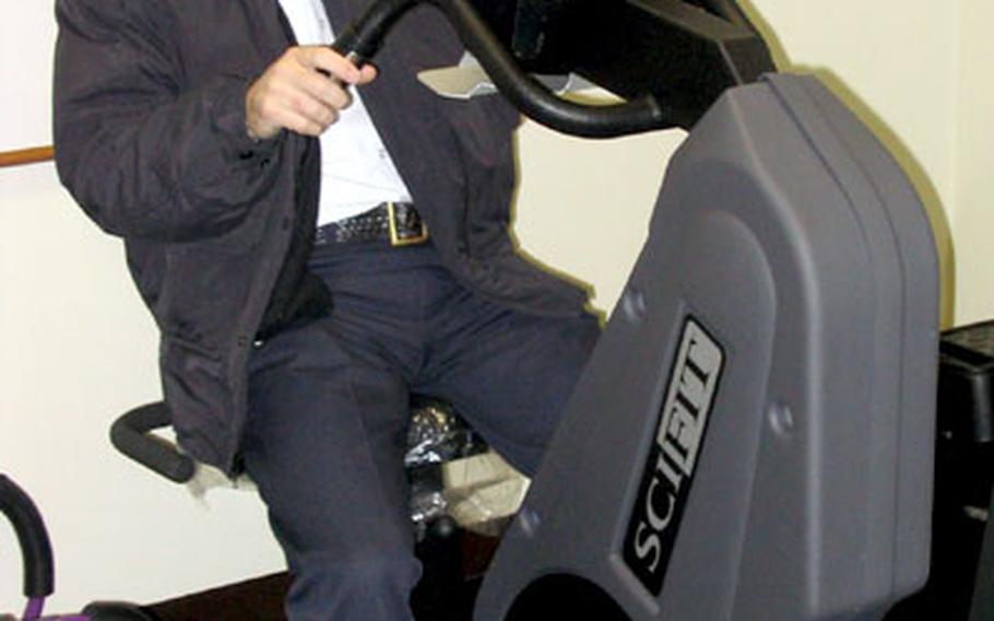 Assistant Fire Chief Jerry Clark climbs aboard and takes a closer look at the stationary bicycle that is just one of the heavy-duty pieces of exercise equipment located in the workout center at Station 15.