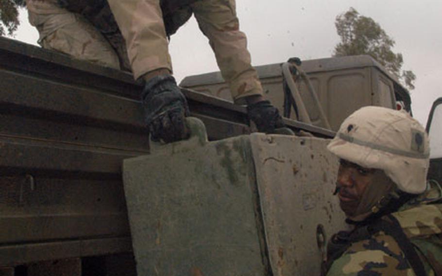 Pfc. Bret Witt, 32, from Madison, Wis., passes boxes of food from a 5-ton truck to Spc. Dervan Dawson, 21, from the Bronx. The soldiers make supply runs from Qayyarah Air Field to smaller posts belonging to the 2nd Battalion, 320th Field Artillery Regiment of the 1st Brigade, 101st Airborne Division.