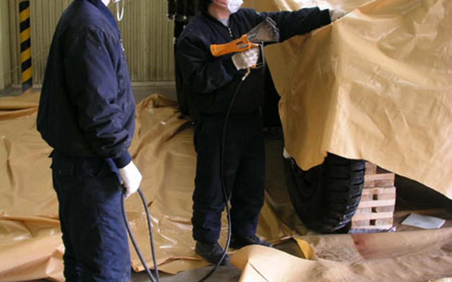 Workers at Osan Air Base, South Korea, begin shrink-wrapping a vehicle, which will help it last longer.