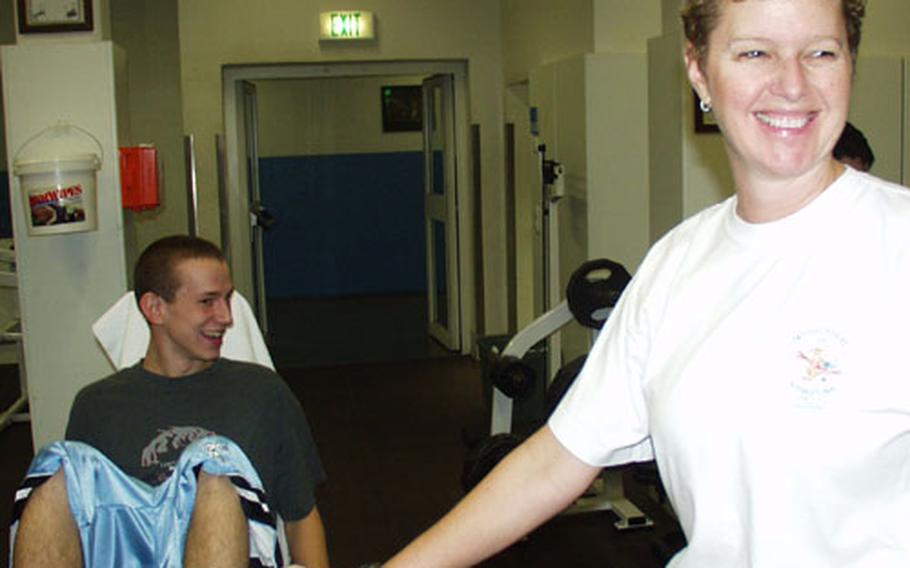 Patch American High School physical education instructor, right, Carol Heffernan and junior Adam Fugent joke during a conditioning class Friday at the Patch Fitness Center.