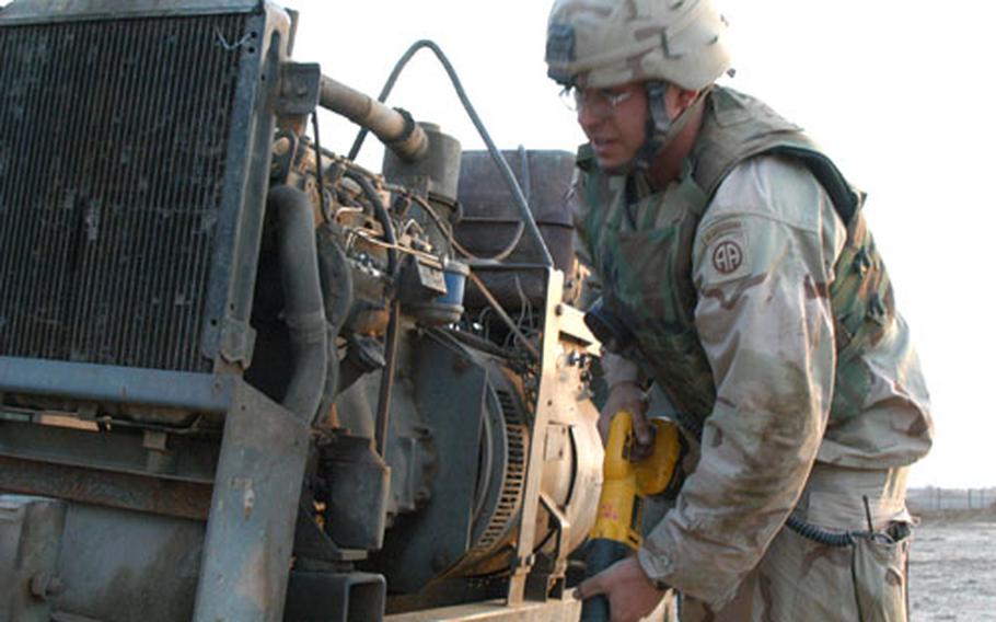 Staff Sgt. James Gaw of the 307th Engineer Battalion from Fort Bragg, N.C., works on an Iraqi tractor outside the south gate at LSA Anaconda. Soldiers converted the tractor into a welder for repairing their equipment.