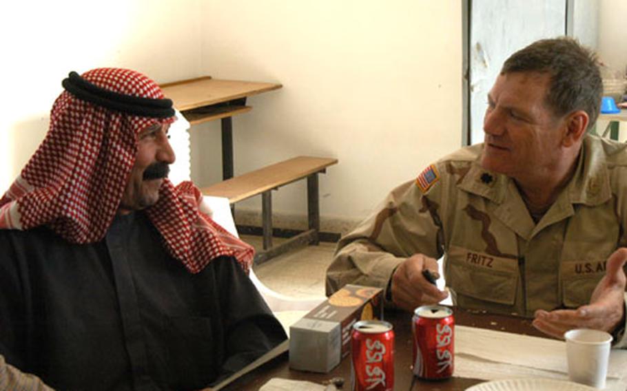 Maj. Randy Fritz of the 308th Civil Affairs Brigade talks with school headmaster Sheik Shahab Ahmed, one of the local Iraqi leaders from Balad involved in the planning of a farm co-operative aimed at boosting farmers&#39; incomes.