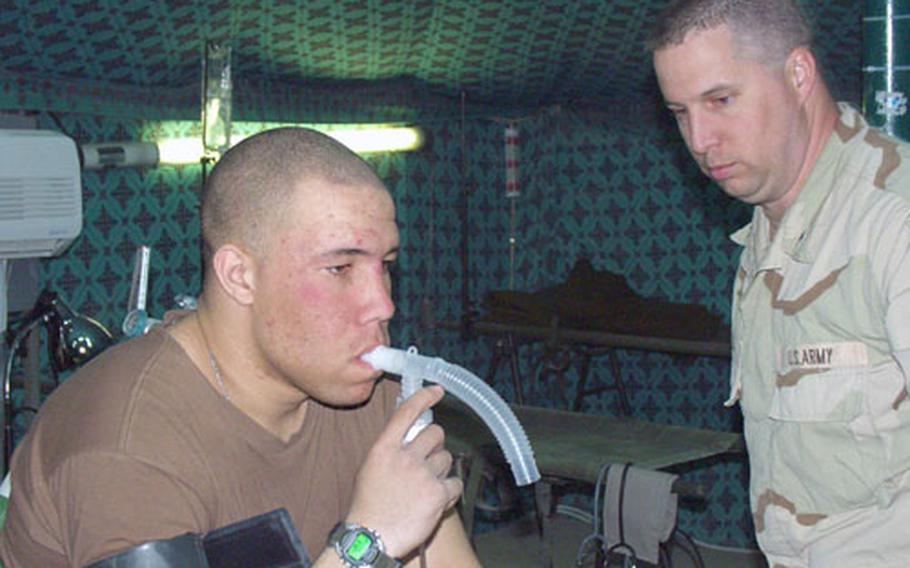 Pvt. 2 Matthew Still, 21, of Mt. Laurel, N.J., inhales a combination of the decongestant Albuterol and oxygen in the medical tent at Camp New York, Kuwait. The soldier, from the 1st Battalion, 6th Field Artillery, is suffering from dust-induced bronchitis, which is epidemic among troops newly arrived in Kuwait. With Still is Sgt. Paul Soulier, 37, a medic with the Alabama National Guard&#39;s 161st Area Support Medical Battalion.