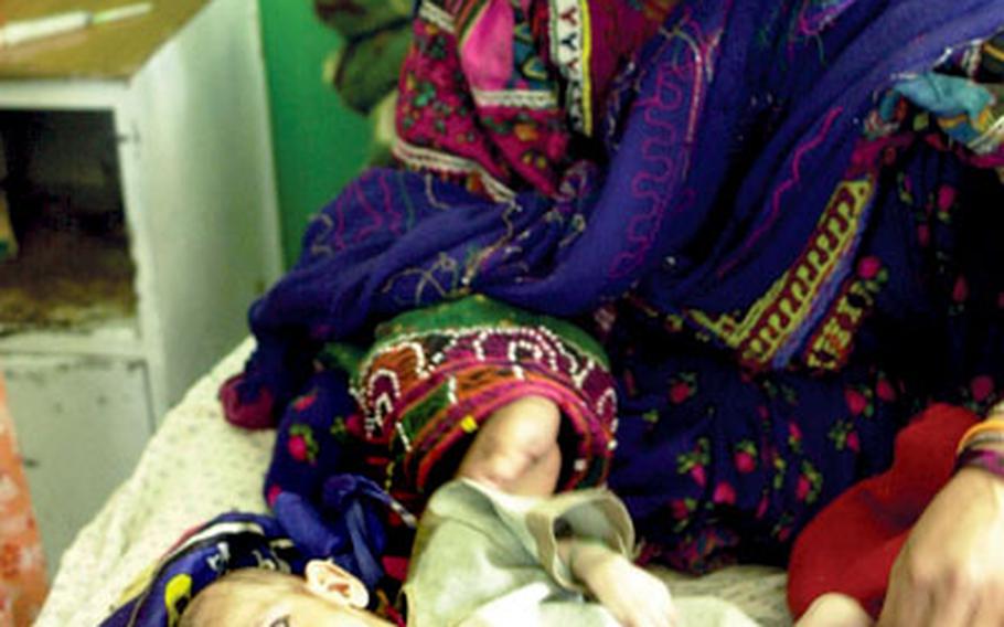 A Baluch woman — one of Afghanistan’s nomadic peoples — watches over her twin babies at the hospital. The twins — a boy and a girl — are both suffering from malnutrition.