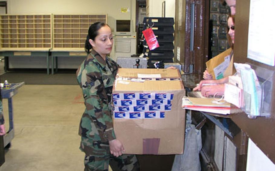 Senior Airman Delia Menchaca, a postal clerk at Osan Air Base, South Korea, hefts a package being picked up by customers at the base post office, which is the busiest within Pacific Air Forces command based on volume of mail handled and number of postal staffers available to handle it. The post office earned an "outstanding" on a PACAF annual inspection earlier this week.