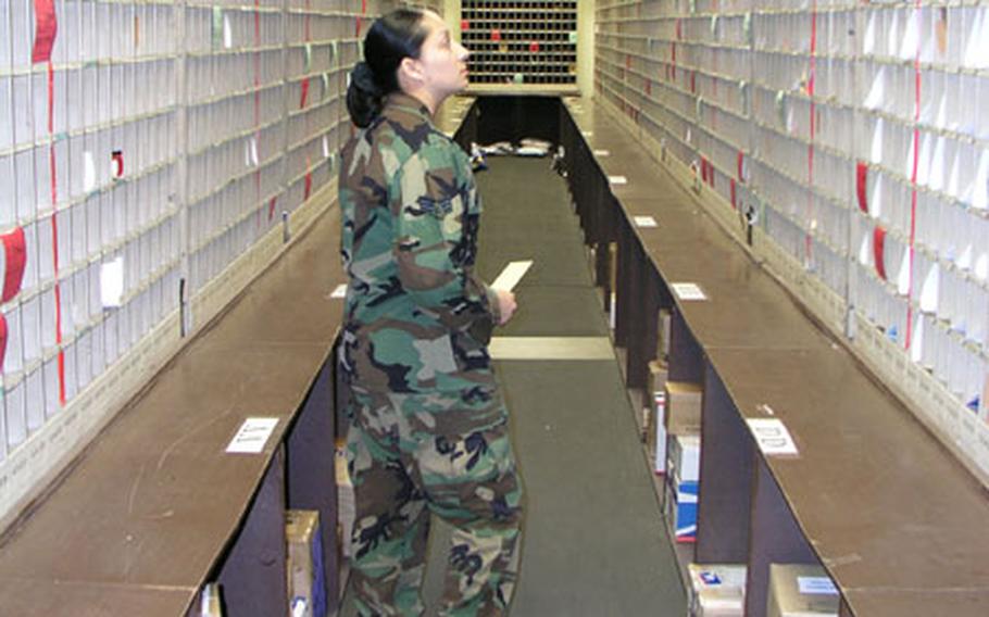 Senior Airman Delia Menchaca looks carefully for a package a customer has come to pick up at the post office on Osan Air Base in South Korea.