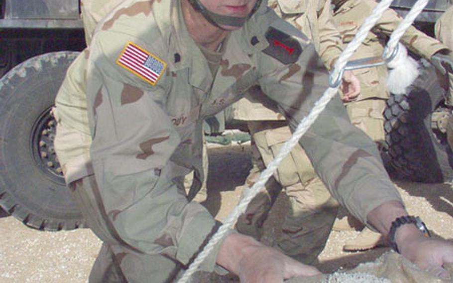 Spc. Eric Houy, 22, of Janesville, Wisc., joins a detail of soldiers from the 1st Infantry Division’s 2nd Brigade, hefting sandbags onto a truck. Houy serves in Delta Company of the 1st Battalion, 35th Field Artillery, from Bamberg, Germany.