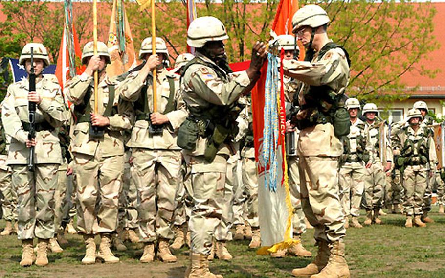 Command Sgt. Maj. Ray D. Lane, 22nd Signal Brigade command sergeant major, and Col. Jeffrey G. Smith, Jr., brigade commander, help uncase the unit flag during the welcome home ceremony Wednesday.