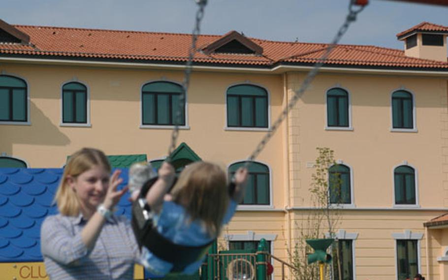 Nicol Gecewich pushes her 2-year-old daughter Kaylie on the swing in a playground surrounded by the four temporary living facility units at Aviano Air Base, Italy. The playground is finished, but the suites — designed to house families processing into and out of the base — won&#39;t be open for a few months. A handful of projects in the $564 million Aviano 2000 construction program are set to open in the fall.