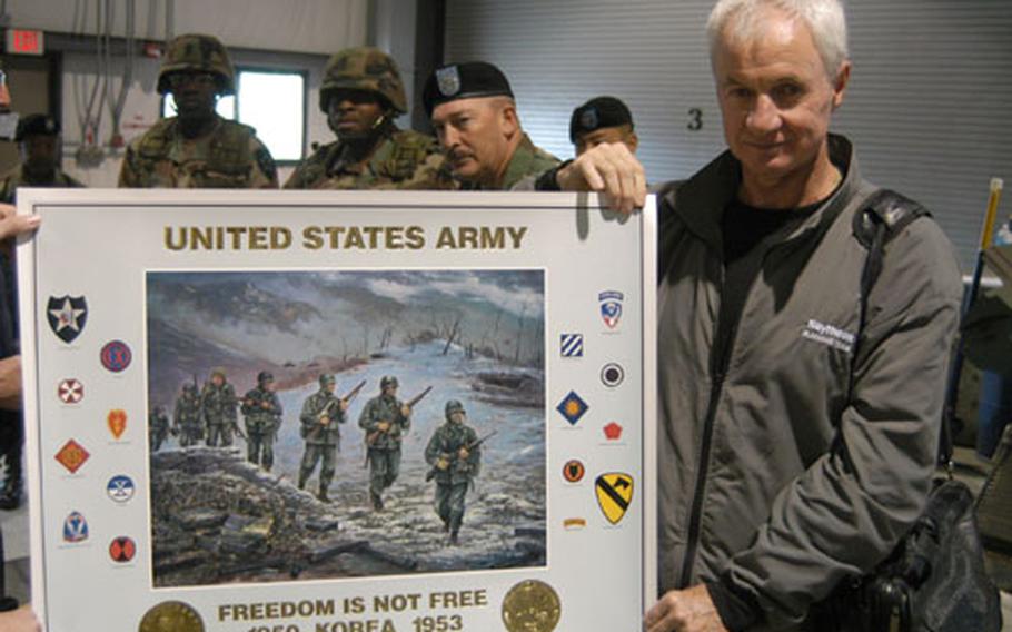 Association of the US Army artist Jim Ryan (right) displays a print he helped produce commemorating the Korean War while (from left) Command Sgt. Maj. James Daniels, Command Sgt. Maj. James Williams, and Command Sgt. Maj. James Lucero look on.