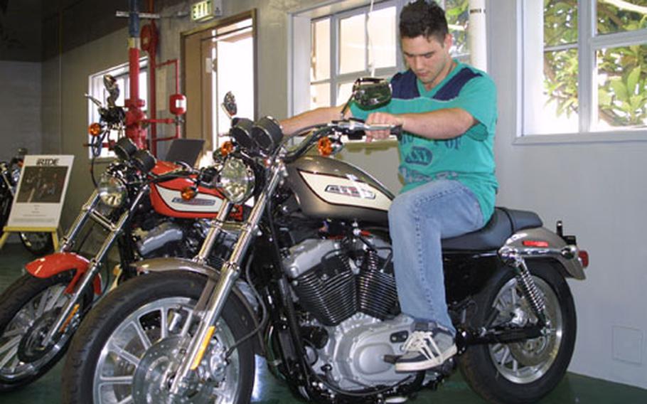 Navy Airman Matthew Guyette, of Helicopter Antisubmarine Squadron 14, checks out a motorcycle at the newly opened Harley Davidson showroom at Naval Air Facility, Atsugi. This and many other bikes are on display. The showroom&#39;s grand opening is scheduled for Saturday, with a ribbon-cutting ceremony at 10 a.m.