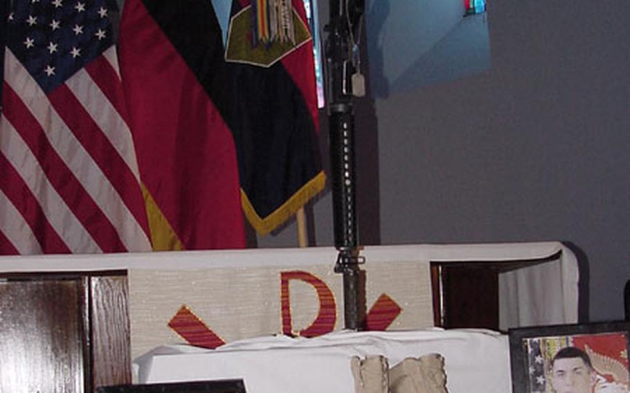 The traditional boots, rifle, helmet and photographs of Pfc. Shawn Edwards are displayed on a podium at Leighton Chapel in Würzburg.