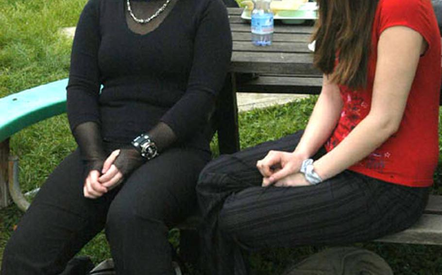 Tenth-graders LaDeanna Spraggins, left, and Amanda Harris sit outside during lunch at Naples American High School in Italy. LaDeanna said that while she understands why revealing clothes are banned, she disagrees with the ban on spiked clothing and doesn’t understand why she was told to remove her watch, which has a skull on it.