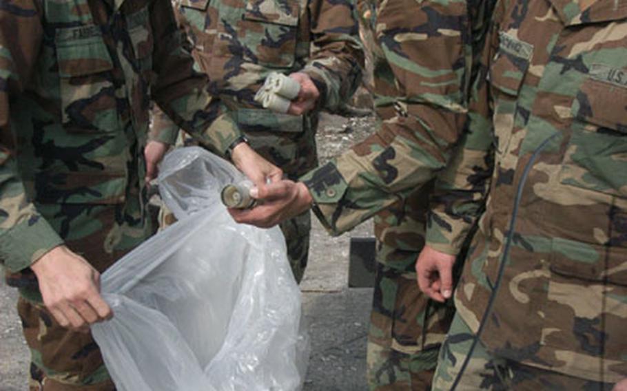 Soldiers collect casing for rubber pellets&#39; casings to be refilled and reused in future non-lethal weapons training.