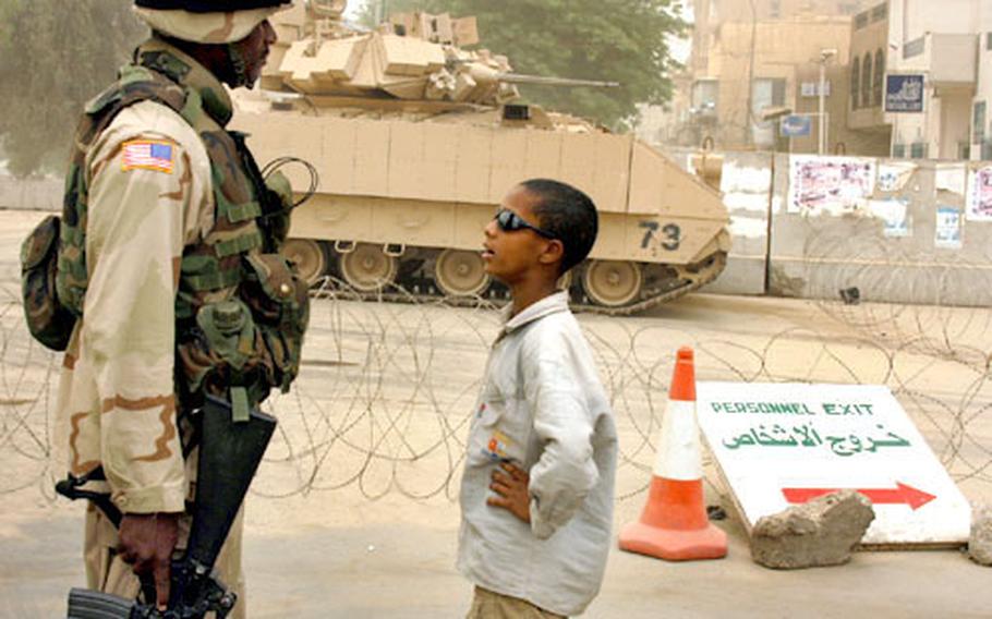 Spc. Kyron Regis and 10-year-old Sayf have a talk at the Palestine Hotel checkpoint.