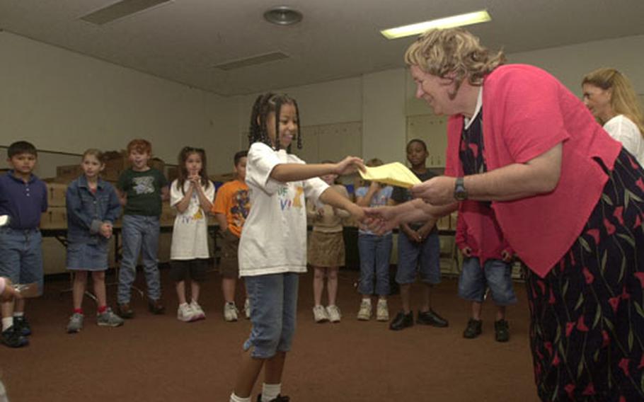 Kinser Elementary School Principal Bill Graham presents Jaren Buckson, a second-grader, with her certificate for not watching television during "turn off your TV week" April 19 to 25. Graham agreed to wear a dress and wig if students didn&#39;t watch any TV during the week, which more than 25 percent of the school&#39;s students did.