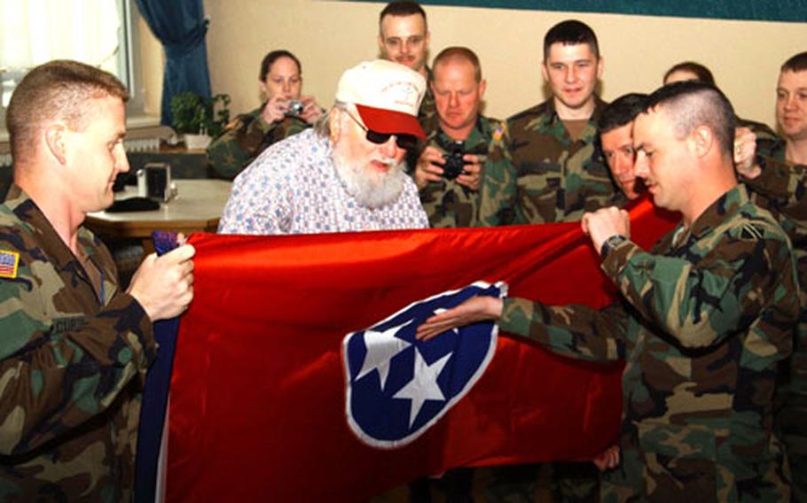 Charlie Daniels signs a Tennessee state flag while members of the Tennessee National Guard look on Thursday at the Wiesbaden Army Airfield Fining Facility. The 2nd Battalion, 115th Field Artillery soldiers are filling in as provisional military police in Stuttgart, Heidelberg, Mannheim and Kaiserslautern, Germany.