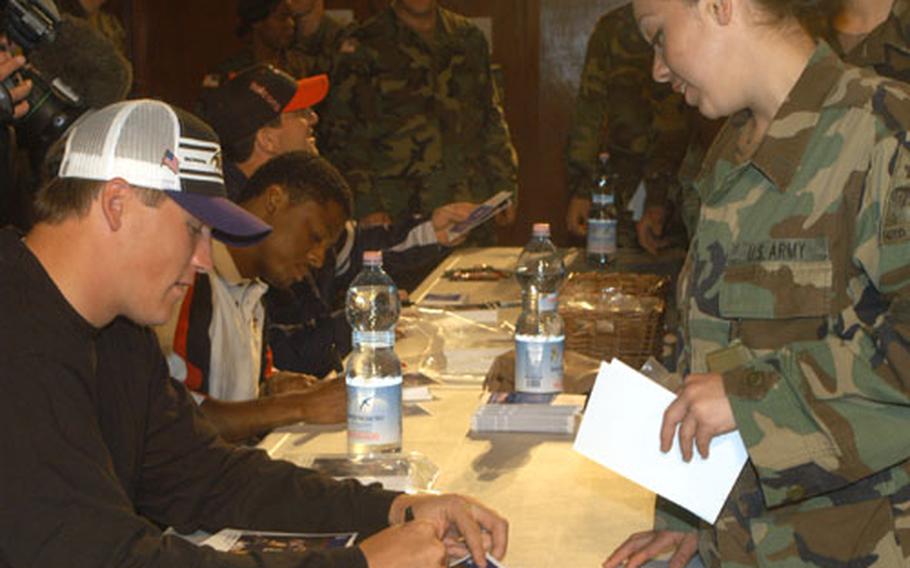 Todd Heap, tight end for the Baltimore Ravens, Warrick Dunn, running back for the Atlanta Falcons, and Keith Brooking, linebacker for the Atlanta Flacons, sign autographs for 1st AD soldiers after talking to them about the experiences in Iraq. The football players said they wanted to thank the troops personally for their sacrifices.