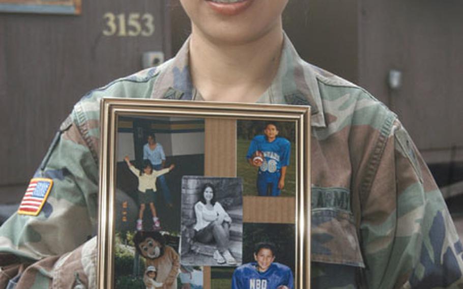 Sgt. 1st Class Viola Millard of Headquarters and Headquarters Company, 38th Infantry Division hold a photos of her four children — Kim, 17, Matthew, 15, Kevin, 14, and Courtney, 10.