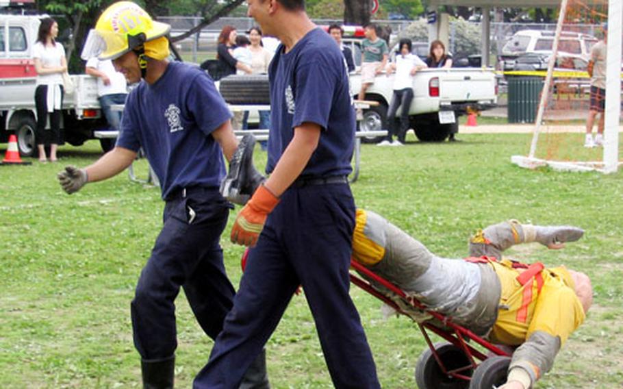 Firefighters from Sasebo Naval Base&#39;s Commander Naval Forces Japan Regional Fire Department return a 185-pound fire victim dummy to the starting point for the next competitor during the Combat Firefighting Challenge on Saturday in Nimitz Park during the MWR-sponsored 2004 Armed Forces Day Sports and Fitness Program.