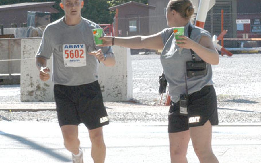 A runner grabs a refreshment during Indianapolis Life 500 Mini Marathon satellite race at Eagle Base in Bosnia and Herzegovina. Some 300 runners, mostly National guardsmen, as well as American civilians, Slovenian, Portuguese, Polish, Latvian, Estonian fellow peacekeepers and even members of the Bosnian armed forces took on the 13.1-mile run Saturday.