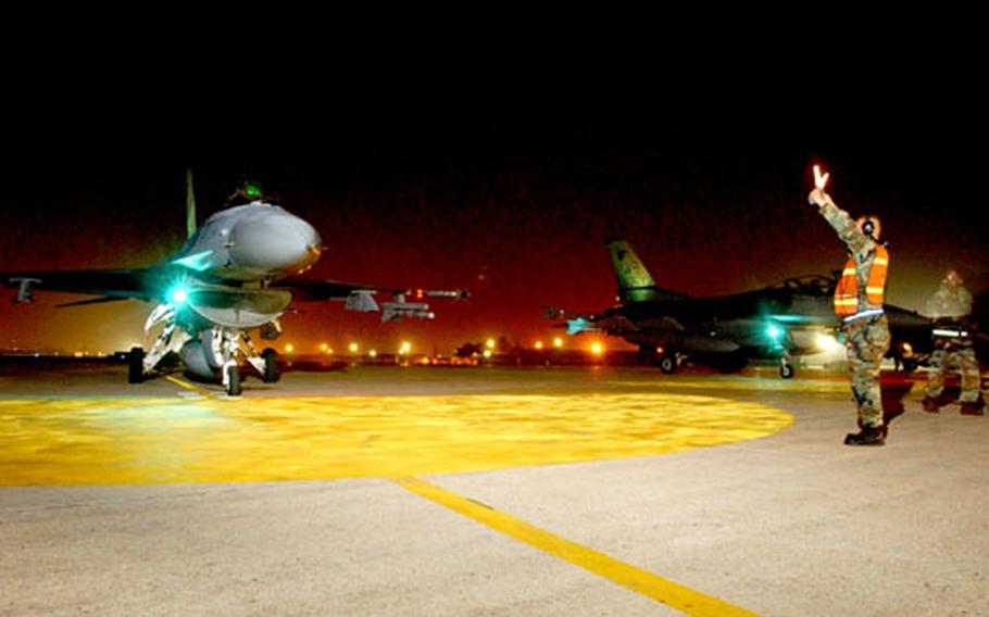 Crew chiefs and weapons personnel from the 8th Maintenance Operations Squadron do their final checks before 35th Fighter Squadron F-16s take off on night missions during a recent surge period.