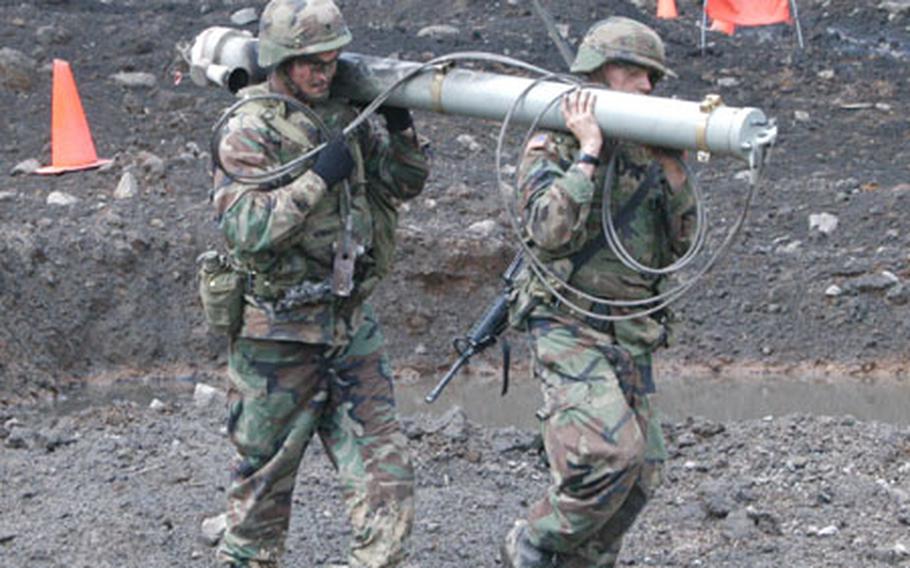 From left: Spc. Price Neal and Pfc. Rory Radtke from the 2nd Engineers Battalion retrieve the rocket that delivered a mine clearing line charge (MICLIC) in Warrior Valley.
