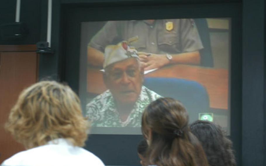 Students listen to World War II veteran Herb Weatherwax talk about his experiences in the attack on Pearl Harbor and his life afterward during a video teleconference Wednesday at Caserma Ederle. The students, taking U.S. history, got a chance to listen to three survivors of the attack and ask them questions.