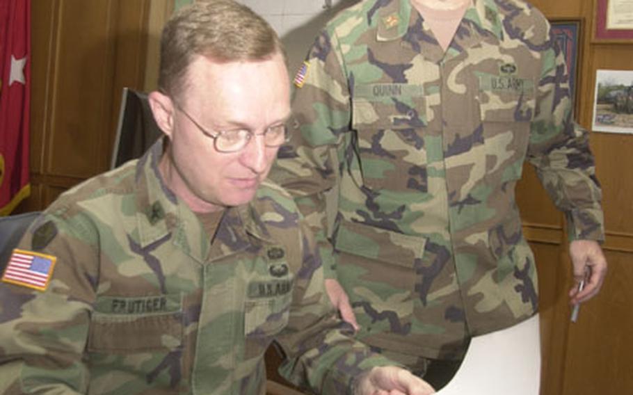 Brig. Gen. Russell Frutiger, (left) the top personnel officer for Army forces in Europe, reviews requests for help from family members of extended 1st Armored Division soldiers with a staff officer.