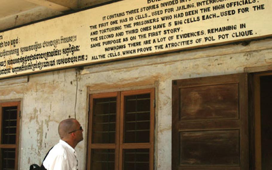 U.S. Air Force Tech Sgt. Bryan Gray reads a sign at Tuol Sleng, a former Khmer Rouge prison that has been converted into a genocide museum.