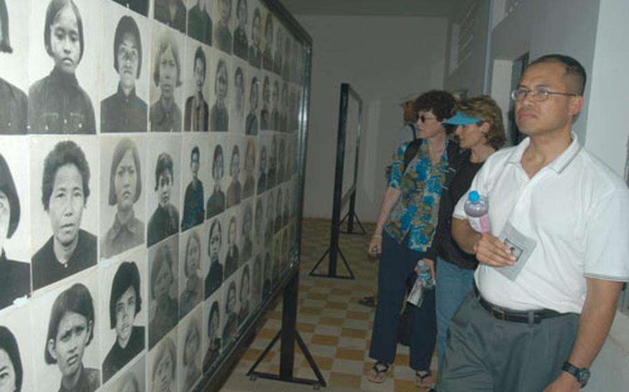 U.S. Air Force Maj. Vira Em (right) looks at photos of assassinated prisoners at Tuol Sleng, a former Khmer Rouge prison that has been converted into a genocide museum.