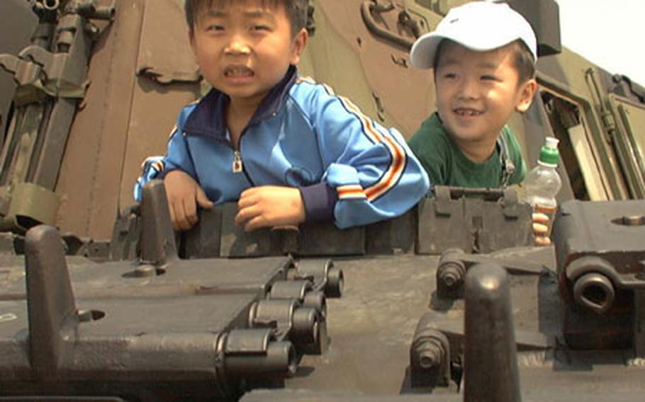At Walker Army Heliport in Taegu, South Korea last May, two boys explore the confines of a U.S. Army M109A6 Paladin self-propelled howitzer during an annual open house at the installation.