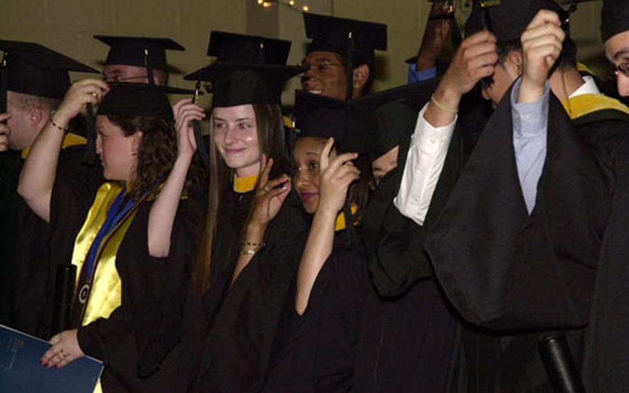 The University of Maryland University College - Korea Class of 2004 switch their tassels to the other side of their mortarboards, symbolizing their graduation Sunday.