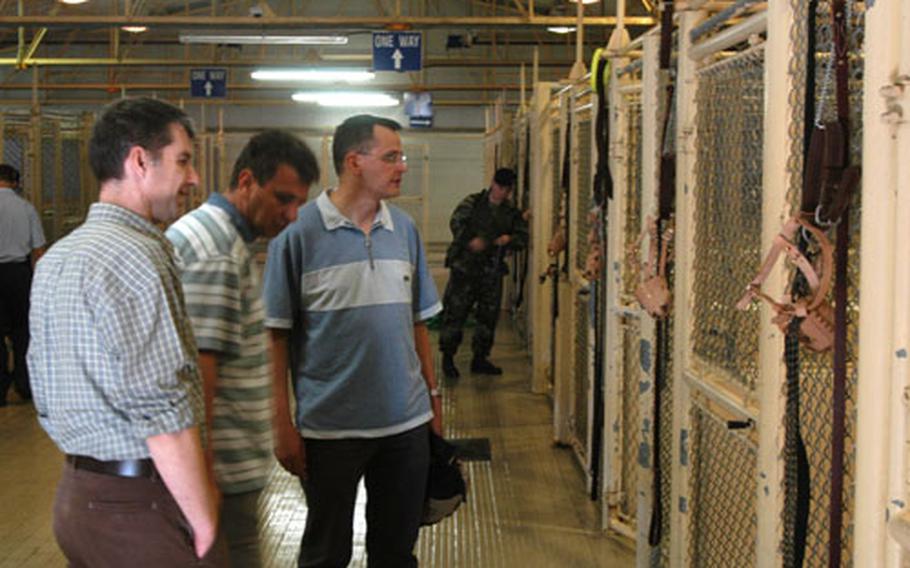 Maj. Darko Semrov, left, Col. Peter Levstek, center, and Maj. Brane Dolenc, three Slovenian army veterinarians, tour the military working-dog kennel at Aviano Air Base, Italy, during a visit Wednesday.