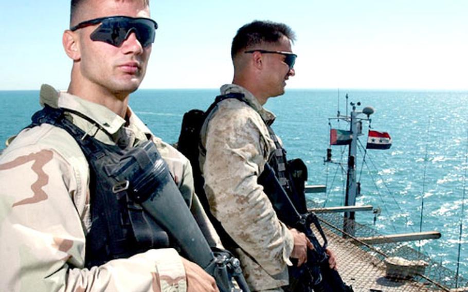 Lance Cpl. Christopher Kotulski and Cpl. Paul O&#39;Donnell stand watch on the flight deck of the Al Basrah Oil Terminal.