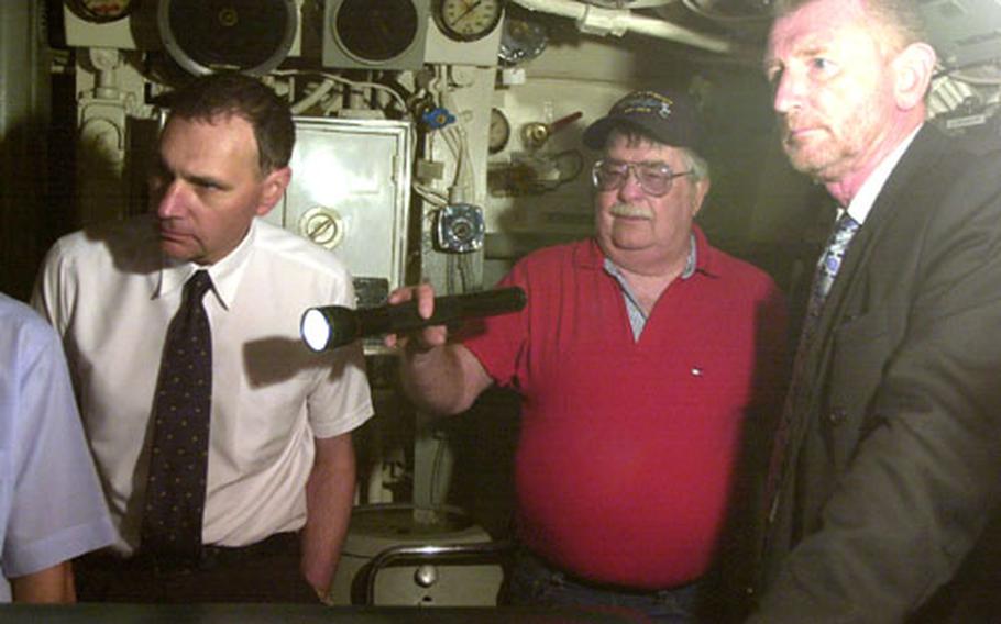 Max Bassett, 68, a retired Navy master chief, uses a flashlight as he gives a tour of the World War II-era submarine USS Razorback on Tuesday in Gibraltar.